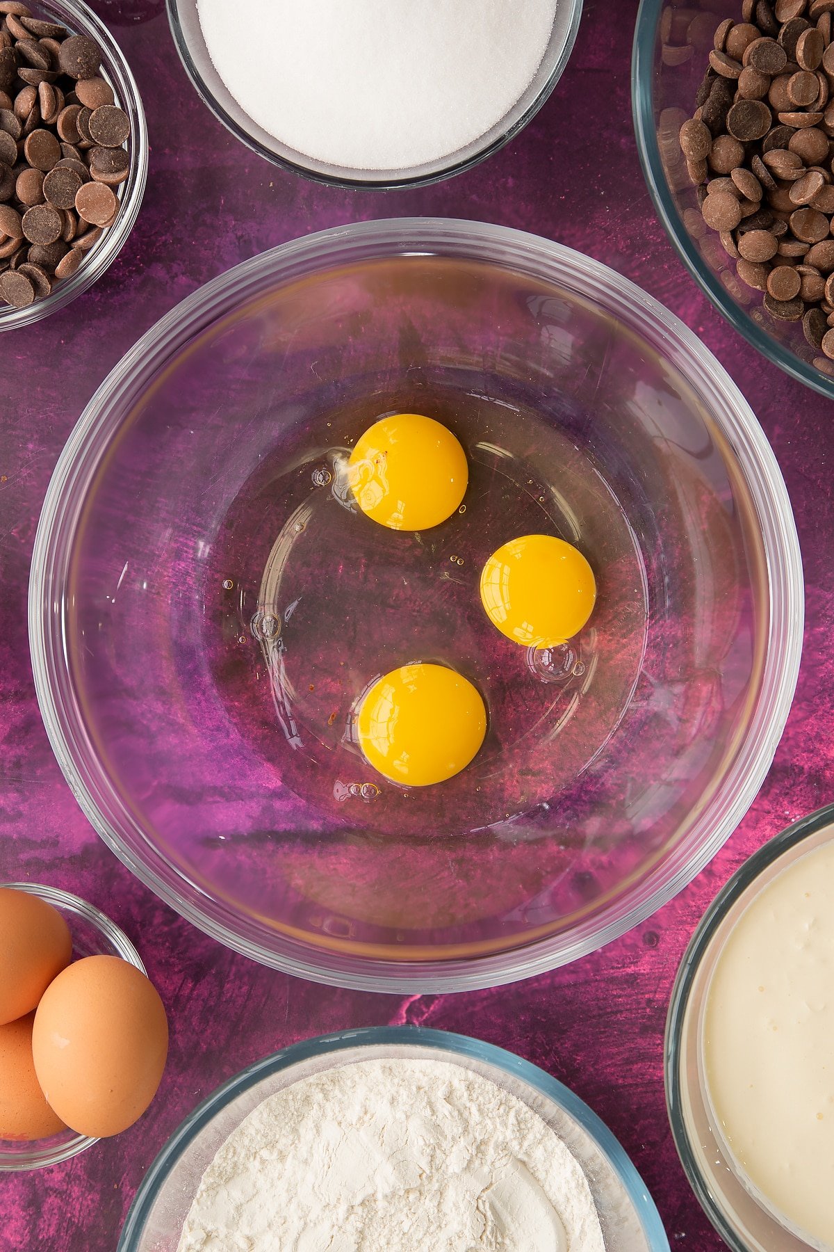 3 eggs in a large clear bowl.