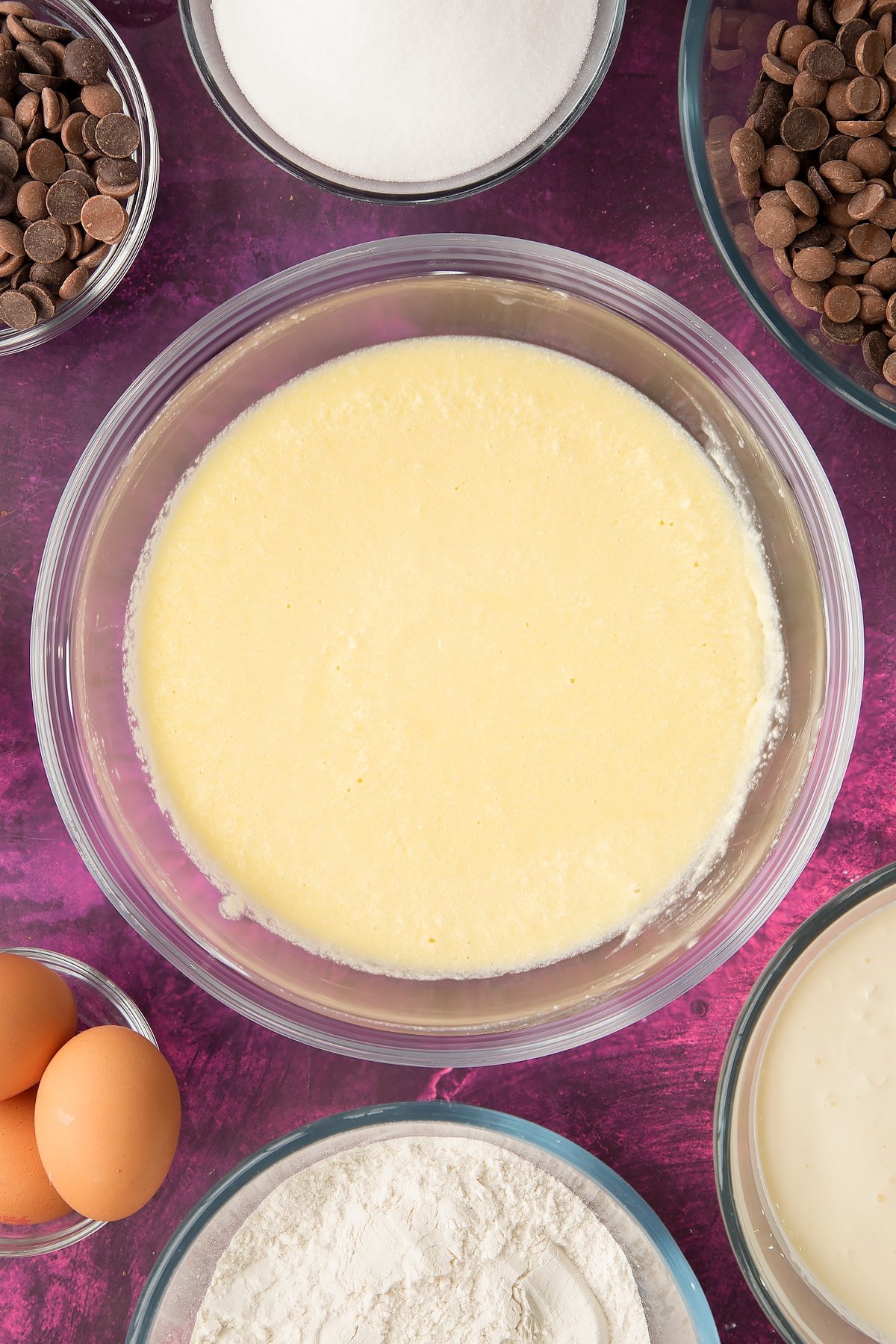 whisked vanilla cake batter in a large clear bowl.