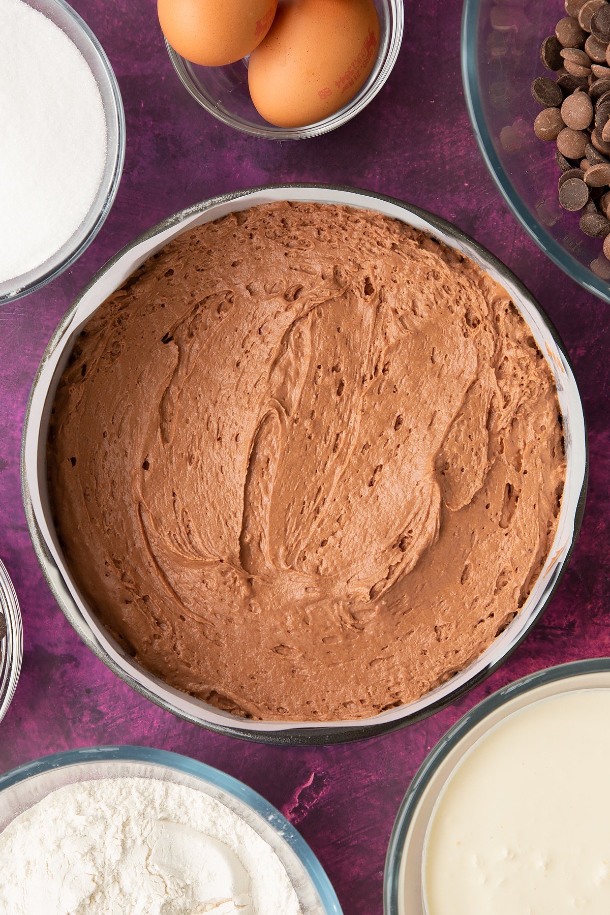 chocolate mouse cake batter in a large lined round cake tin.