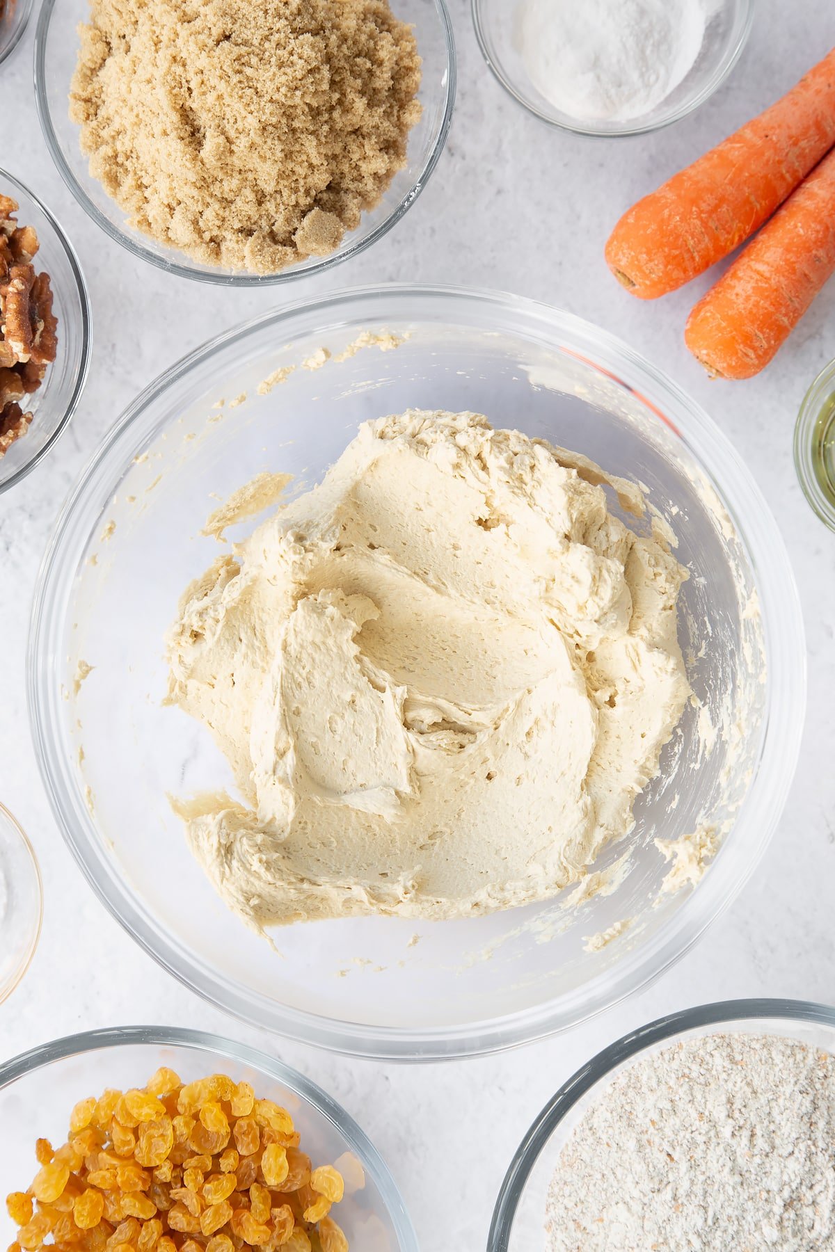 whisked carrot cake batter in a large clear bowl.