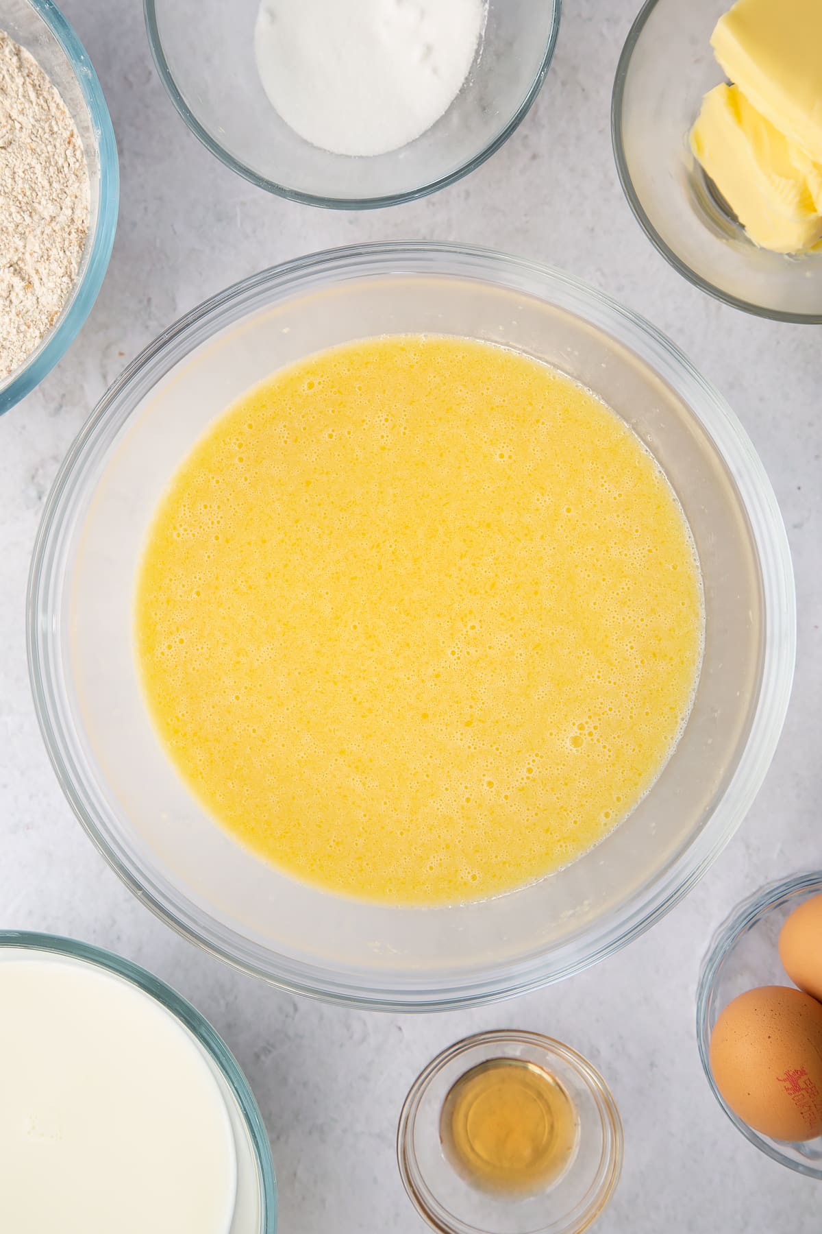 whisked eggs, milk, melted butter and vanilla in a large clear bowl.