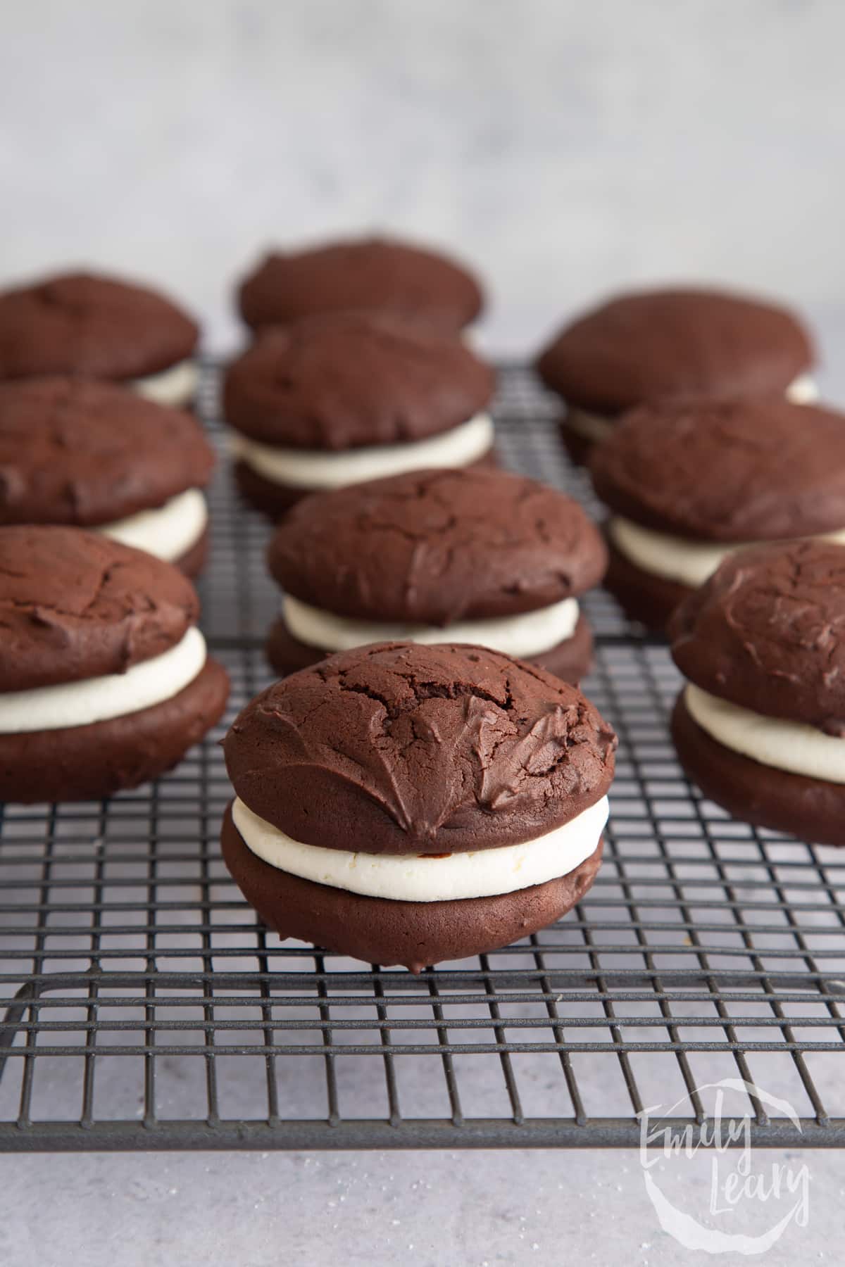 Whoopie pies lined up on a wire cooling rack.