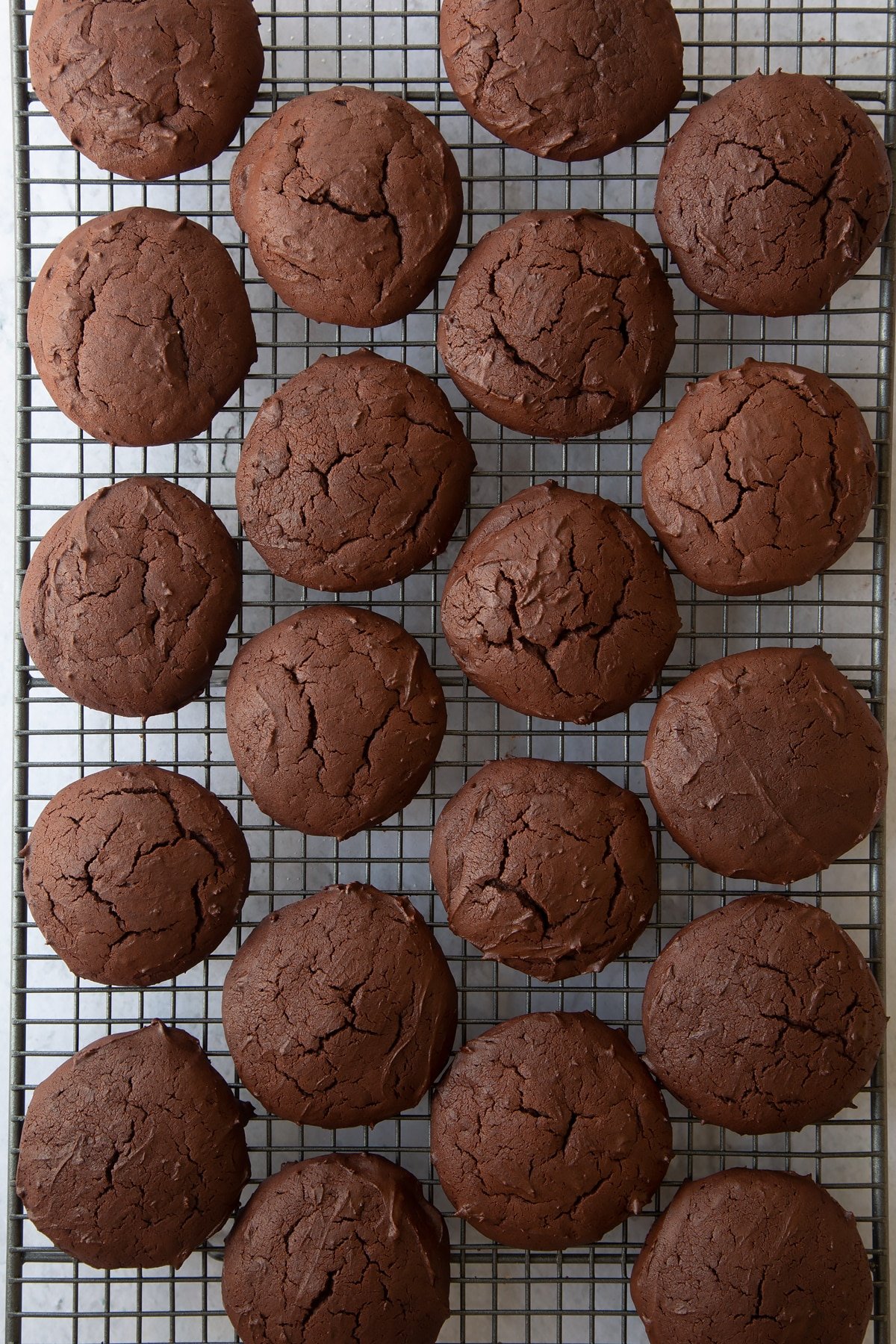 a wire cooling rack covered in chocolate whoopie pie cookies.