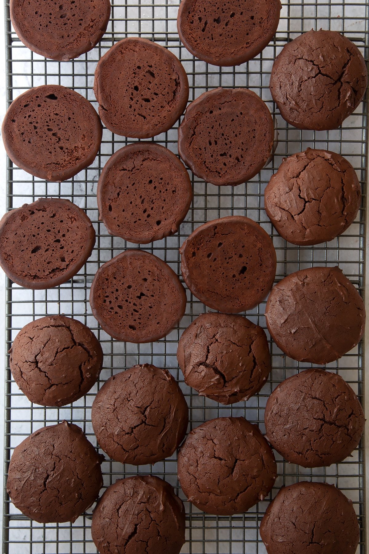 chocolate whoopie pie cookies turned over on a wire cooling rack.