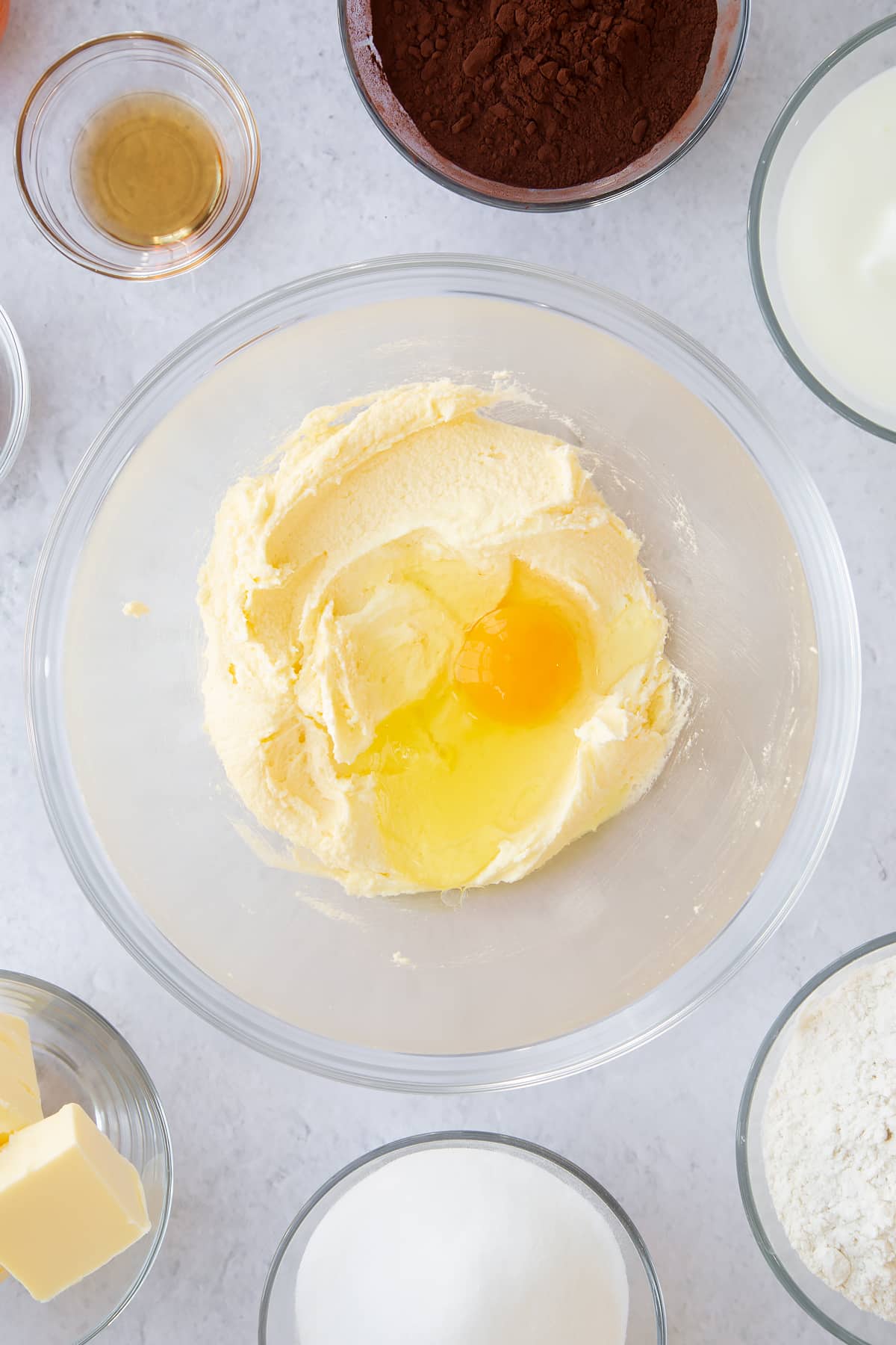 whisked butter and sugar mix in a large clear bowl topped with one egg.