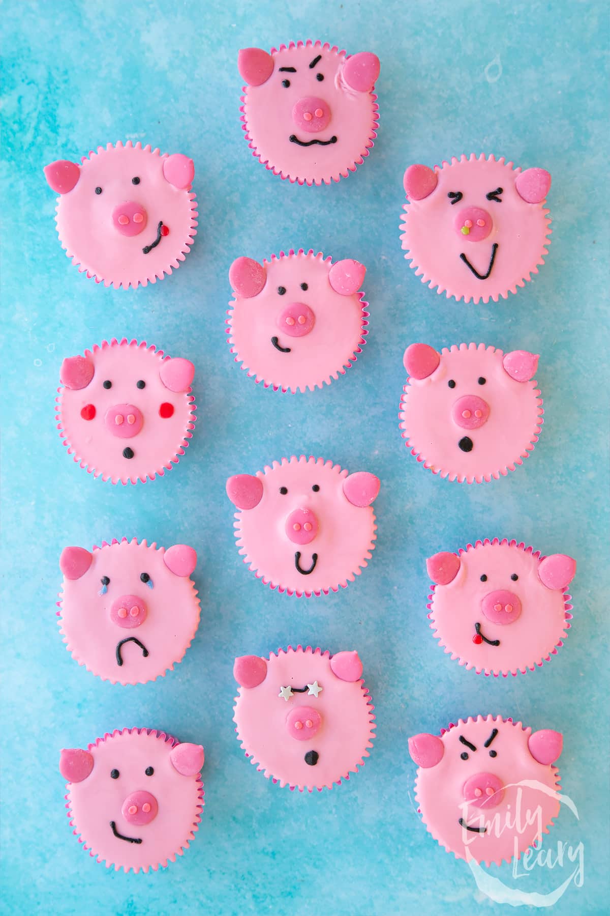 overhead view of Pink pig cupcakes in rows portraying different faces.