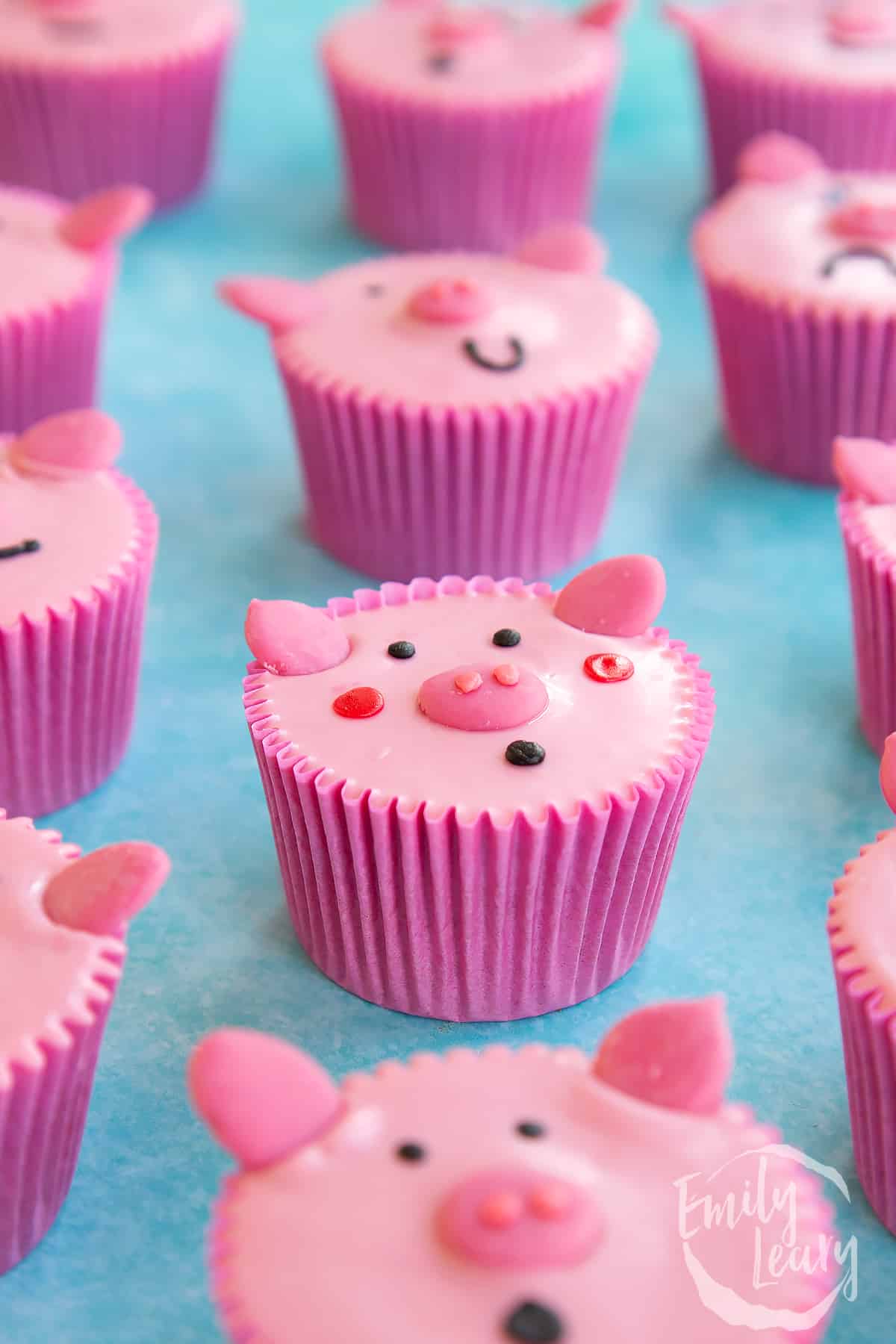 Pink pig cupcakes in rows portraying different faces.