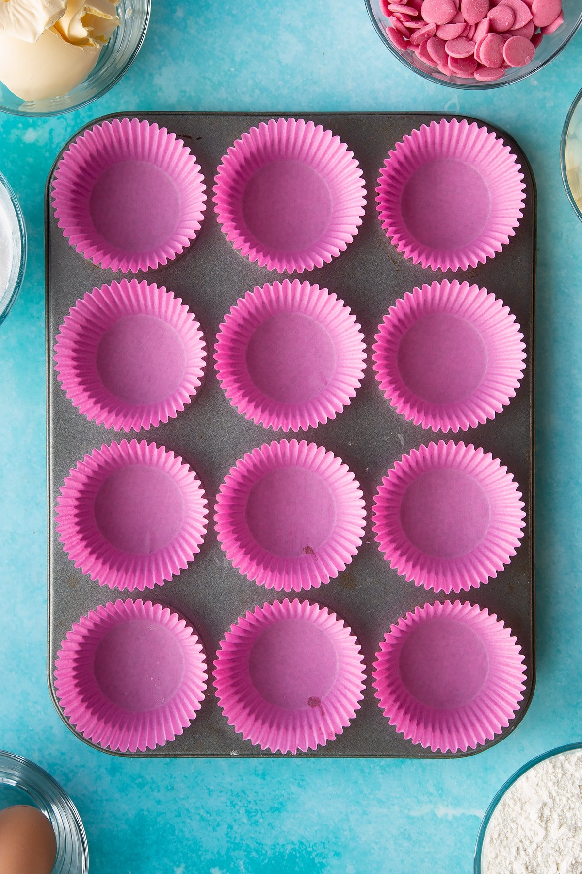 pink cupcake liners in a cupcake tray.