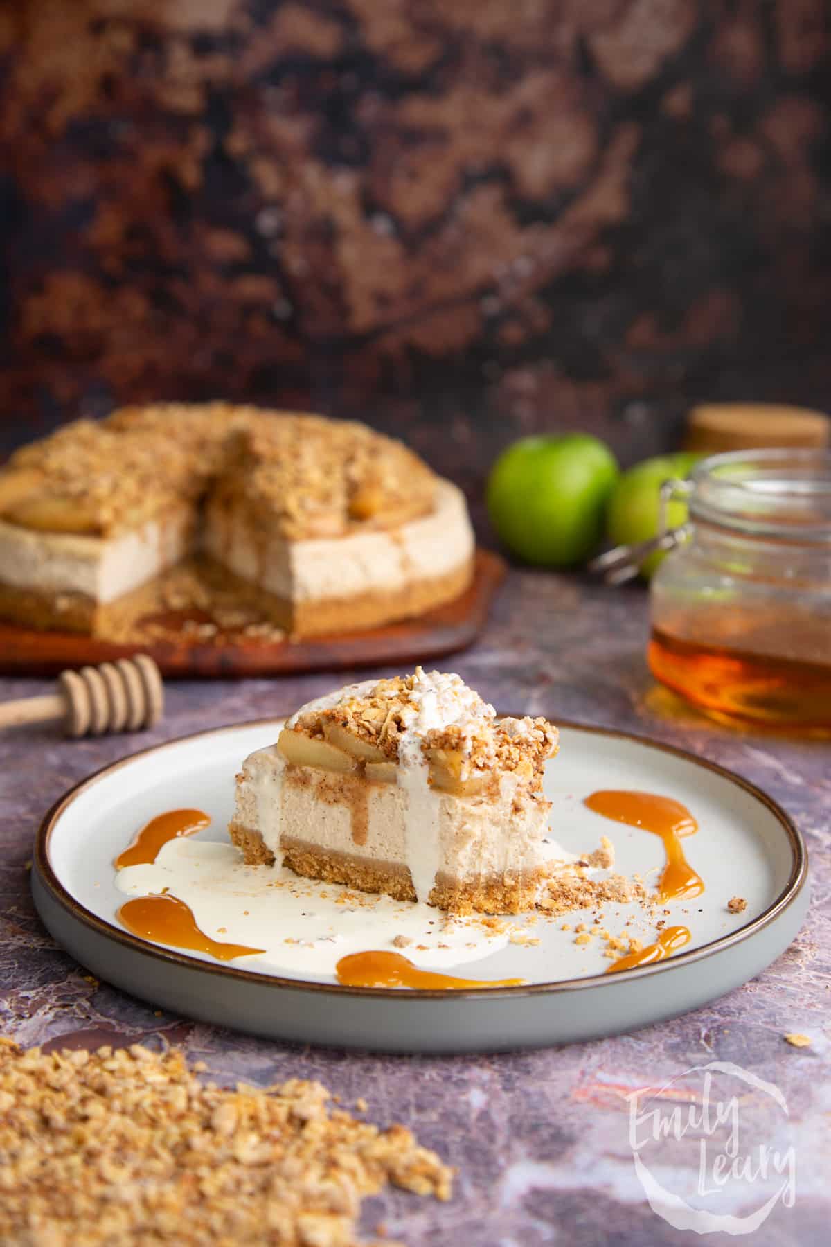 Finished Apple crumble cheesecake slice on a white decorative plate.