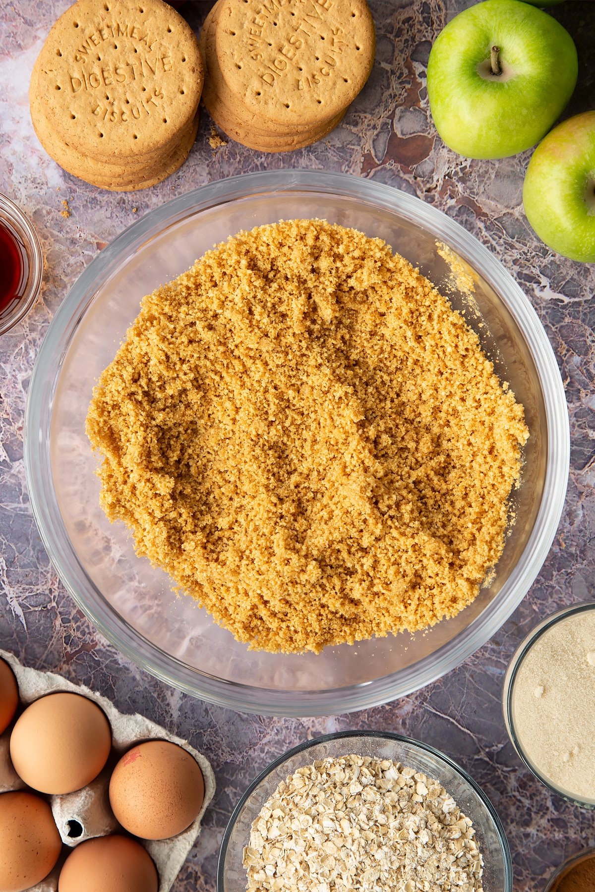 Stirring the biscuit crumbs together with the melted butter and sugar. 