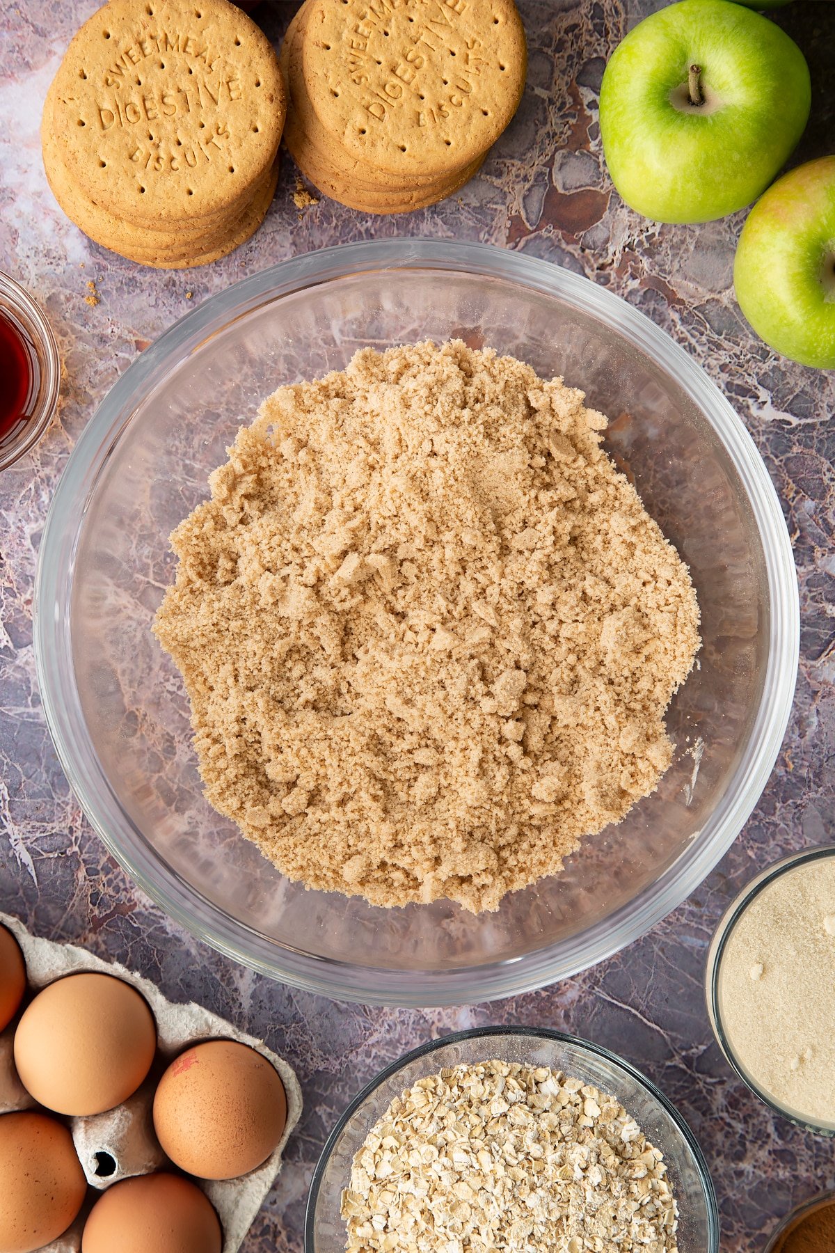 Adding the ingredients for the crumble into the clear mixing bowl.