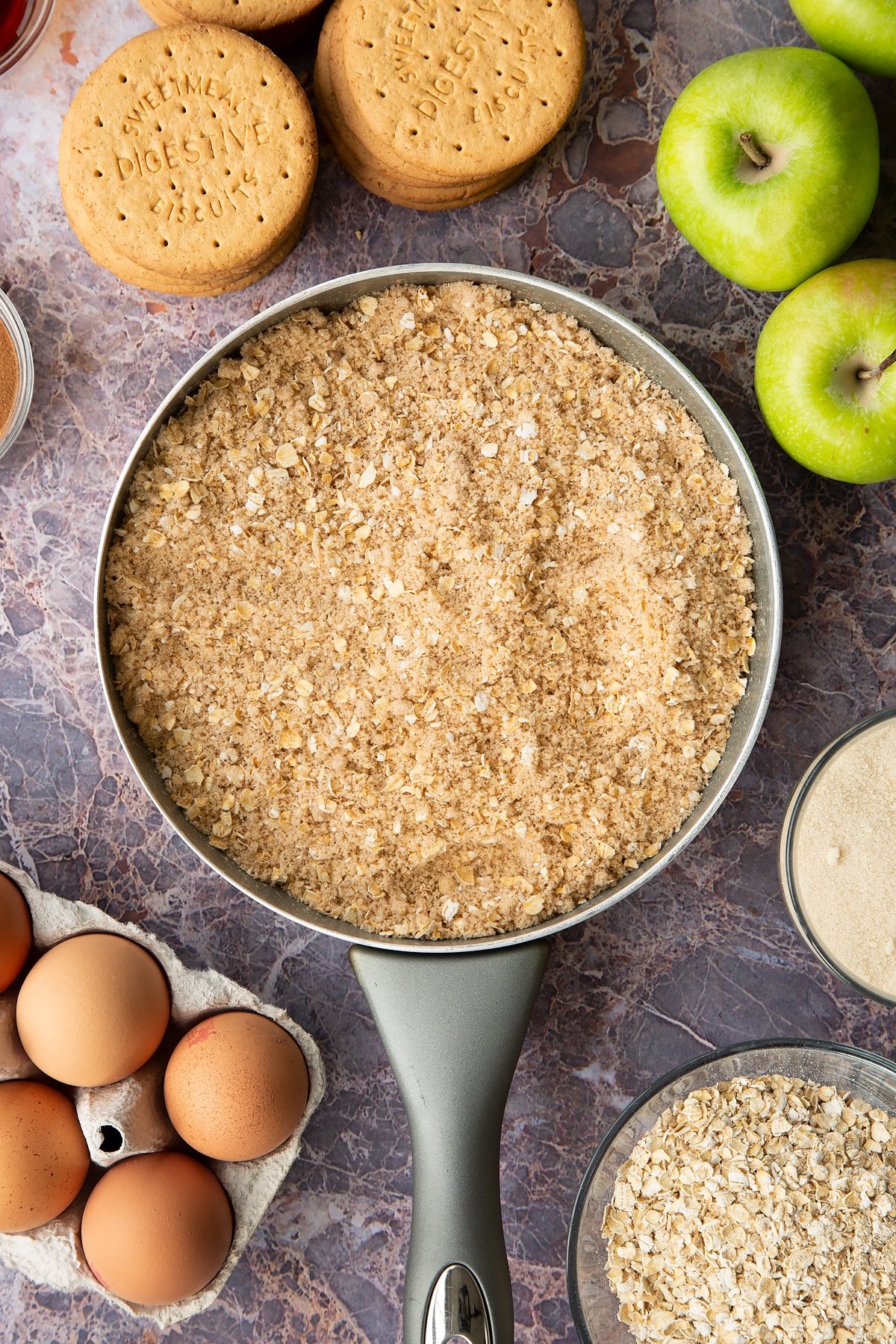 Adding the crumble mixture to the frying pan. 