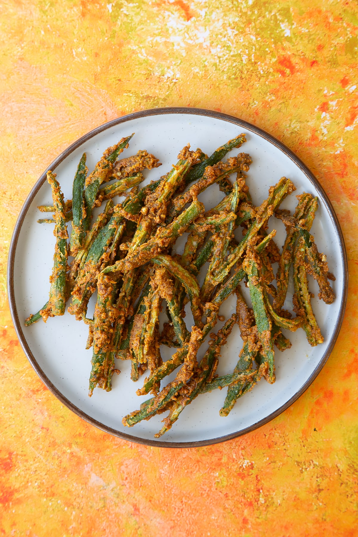 Overhead shot of the finished kurkuri bhindi on a white plate.