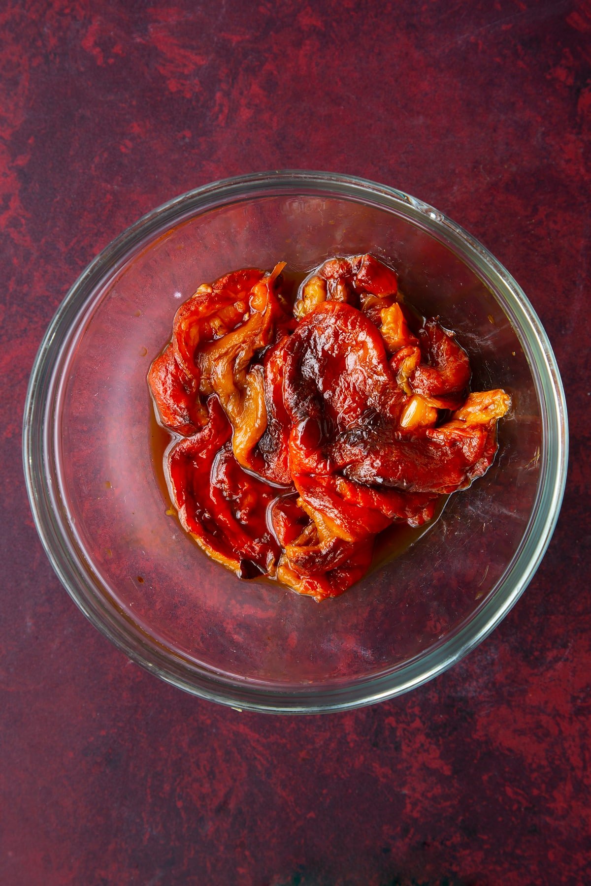 roasted red peppers deseeded and peeled in a clear bowl.