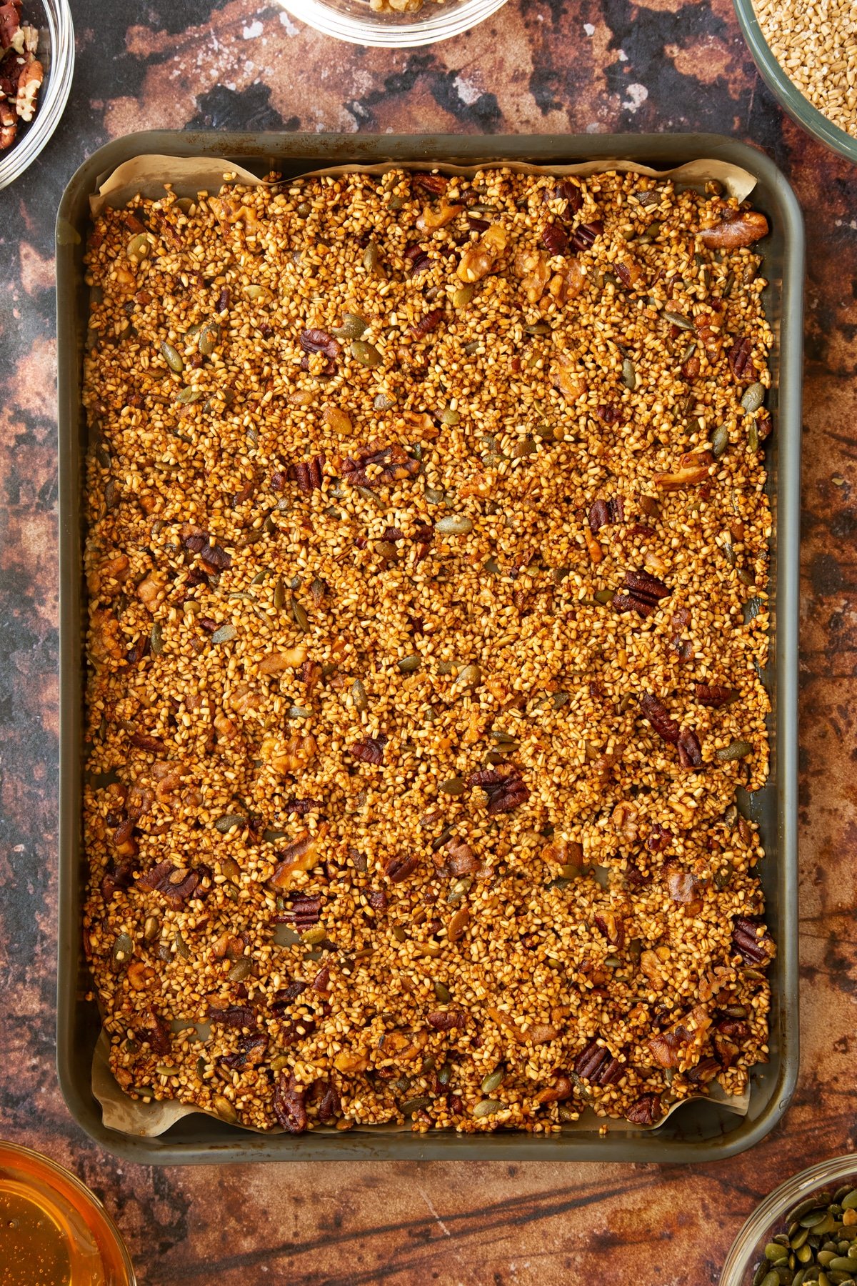 cooked steel cut oats mixture laid out on a baking tray lined with baking paper.