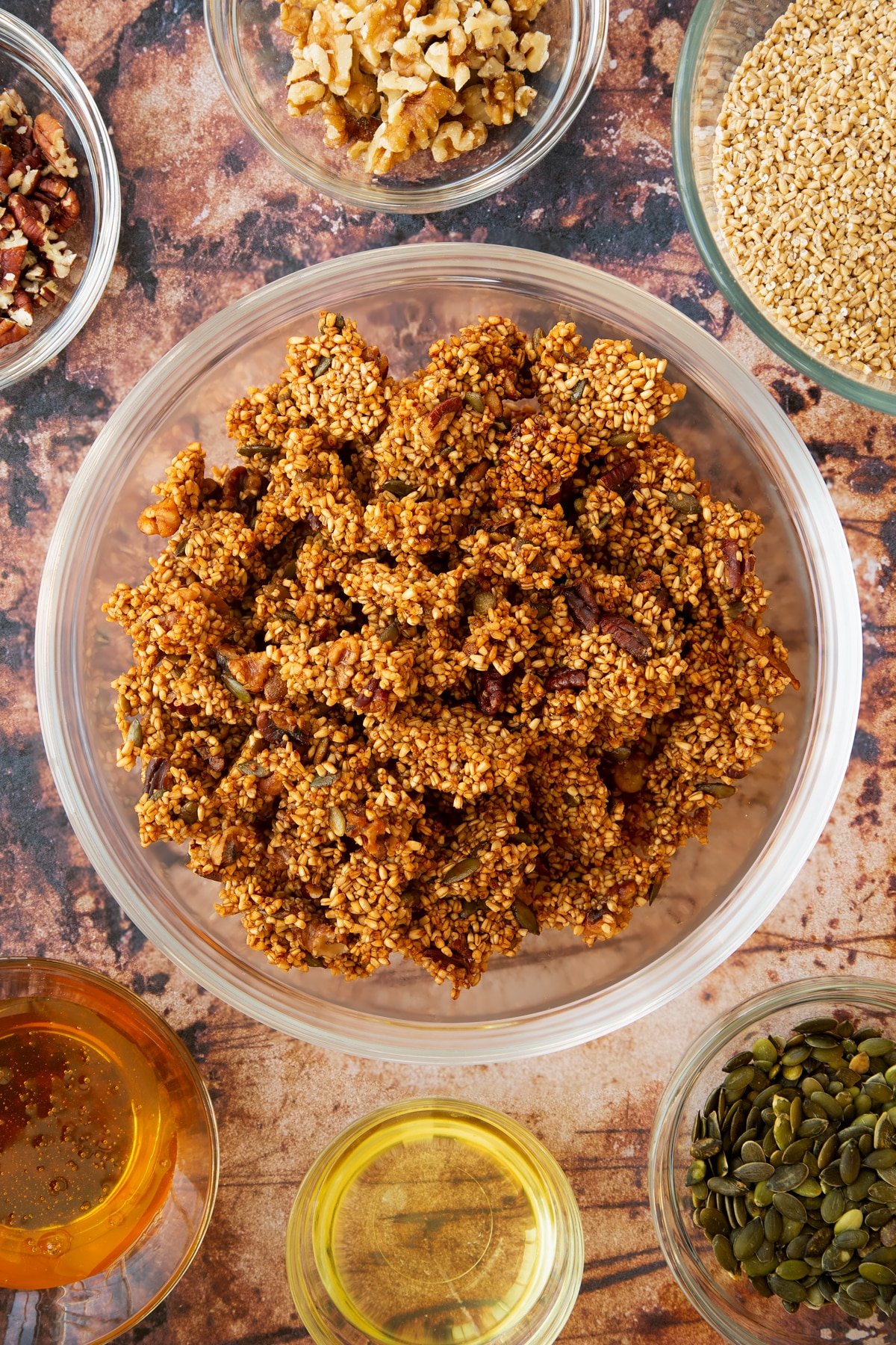 cooked Steel cut oats granola broken into pieced in a large clear bowl.