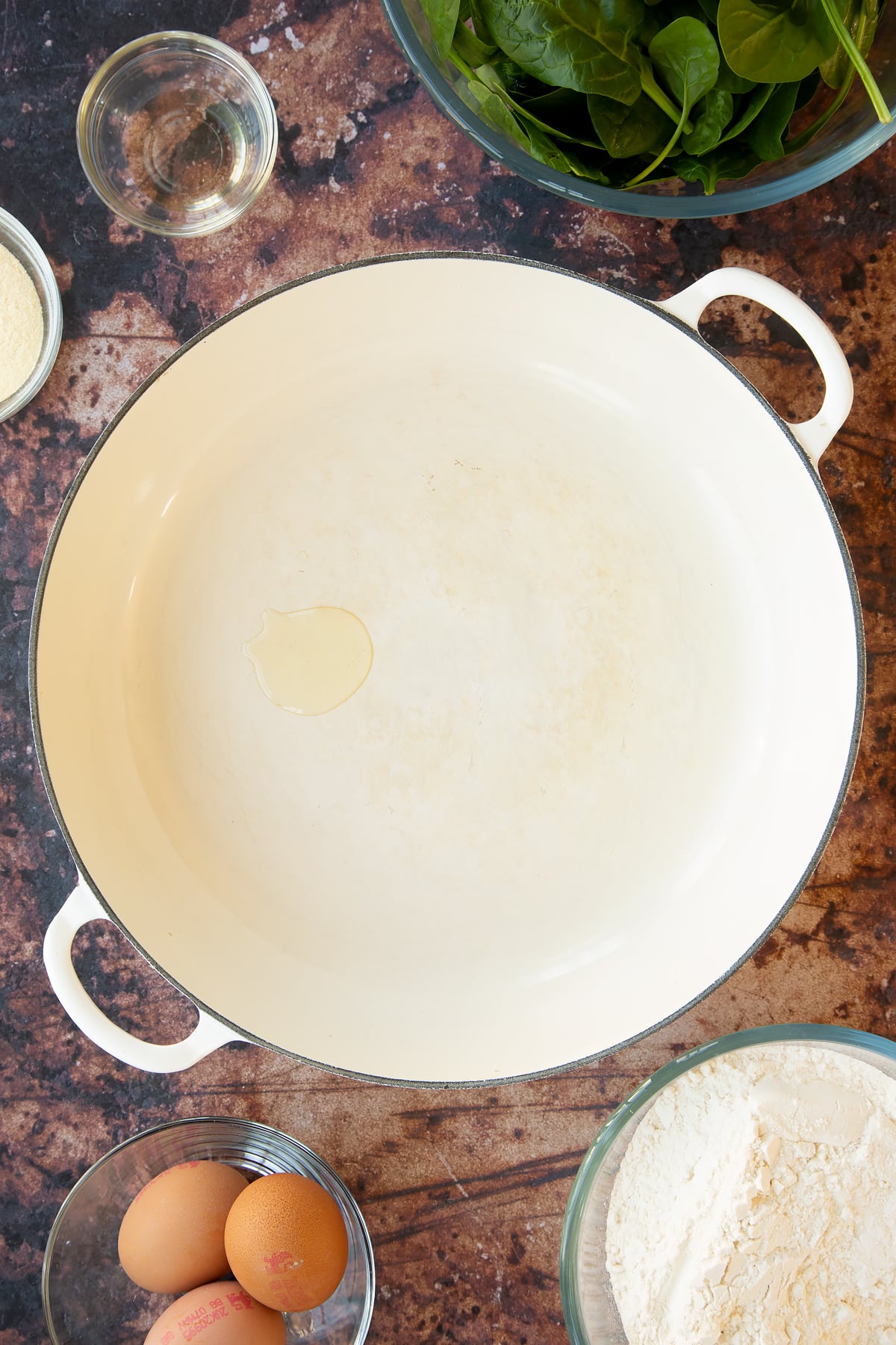 a large white pan with a small drop of oil in the bottom.