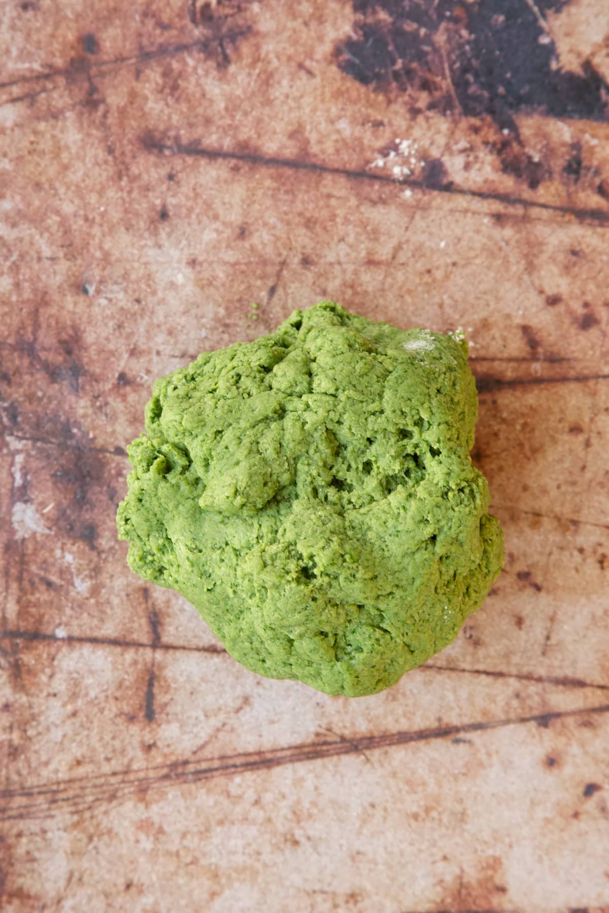 green pasta dough on a brown background.