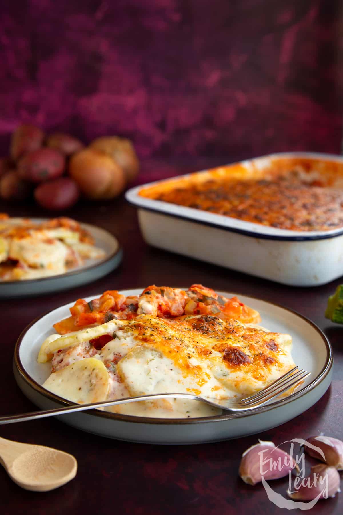 Side on shot of a plate of vegetarian potato lasagne.