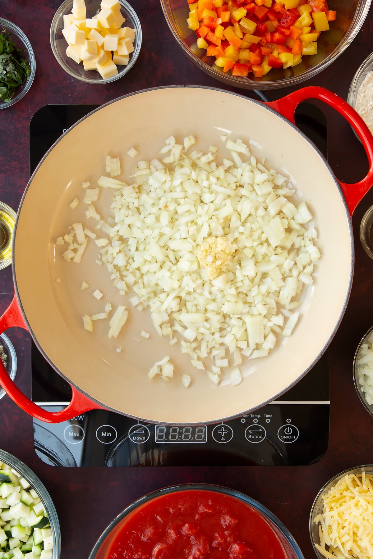 Overhead shot of some diced onions in a pan on a cooker.