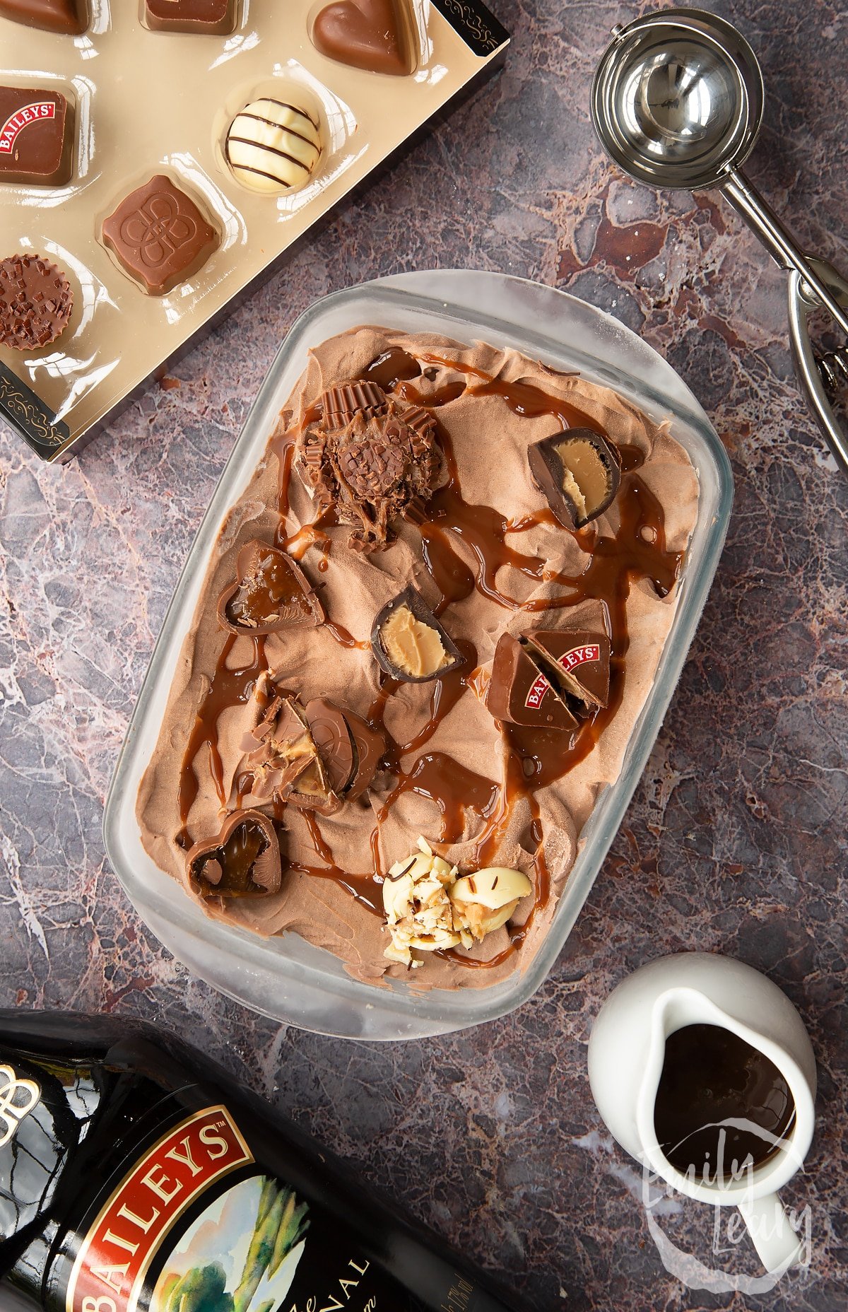 baileys ice cream in a pyrex dish topped with baileys chocolates on a marble background.