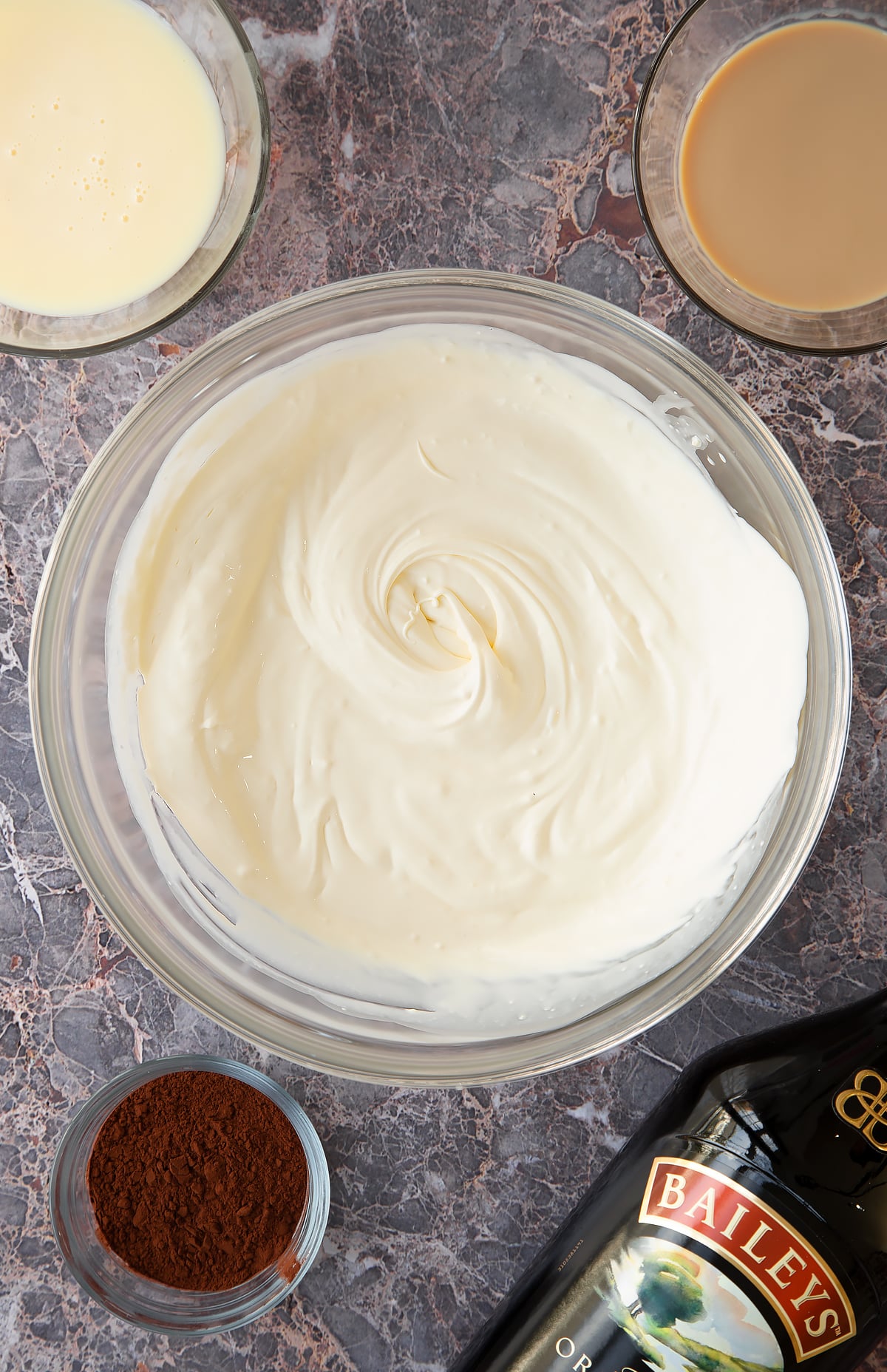 whisked cream in a large clear bowl.