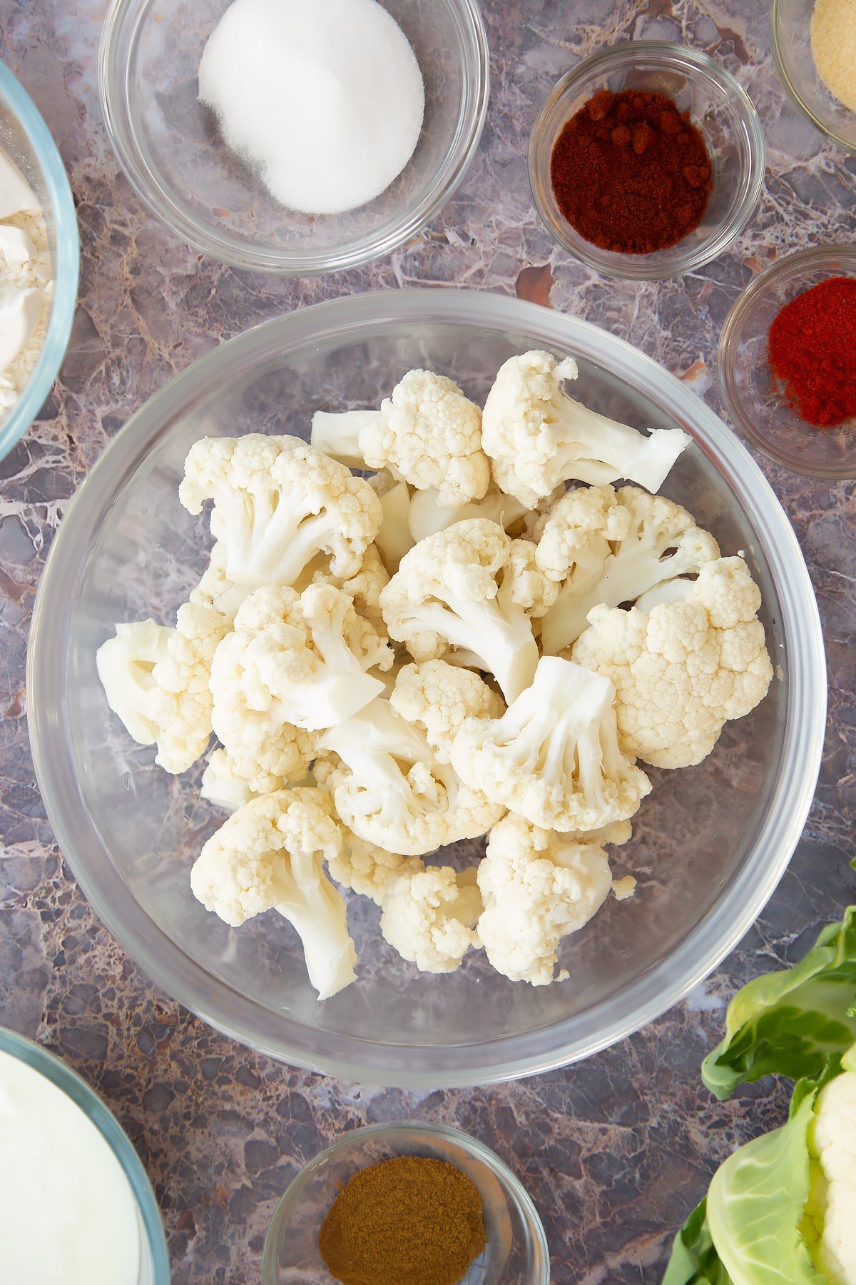 cauliflower florets in a large clear bowl.