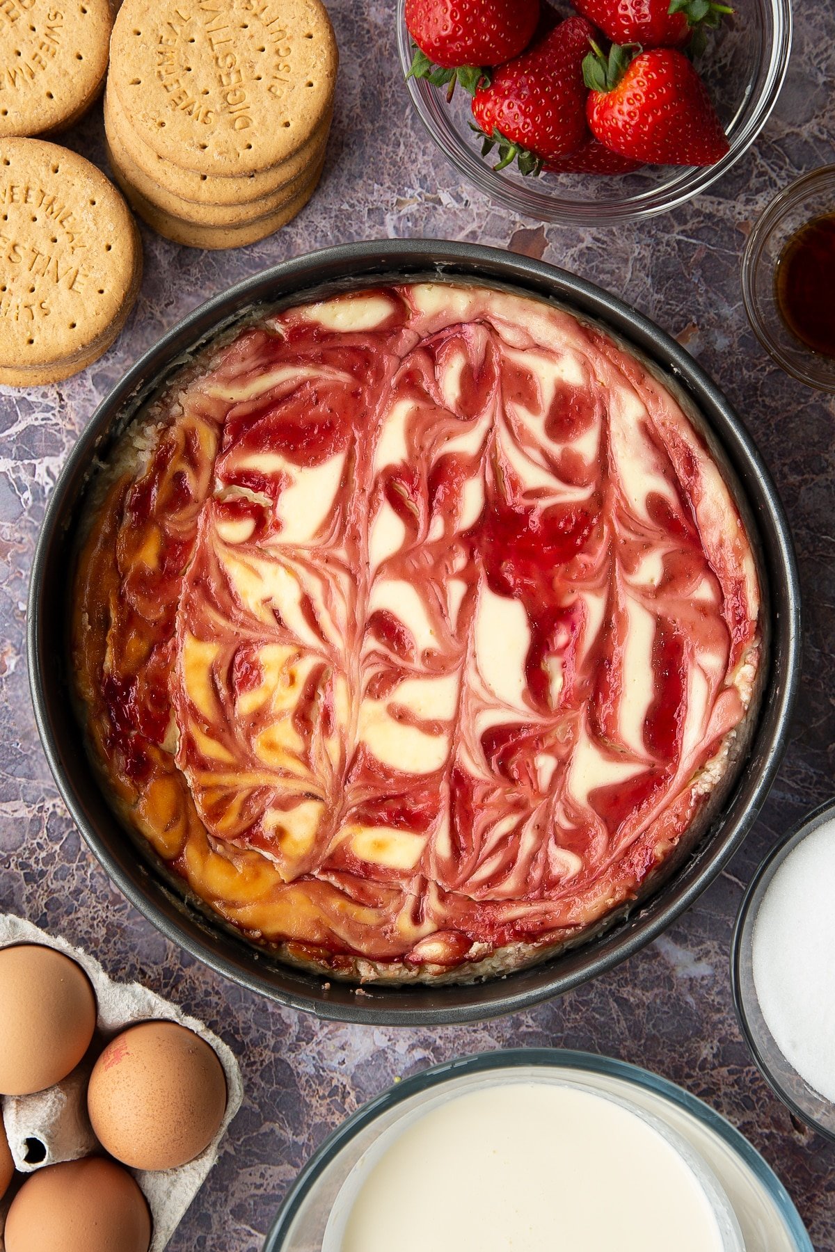 baked strawberry swirl cheesecake in a large springform cake tin.