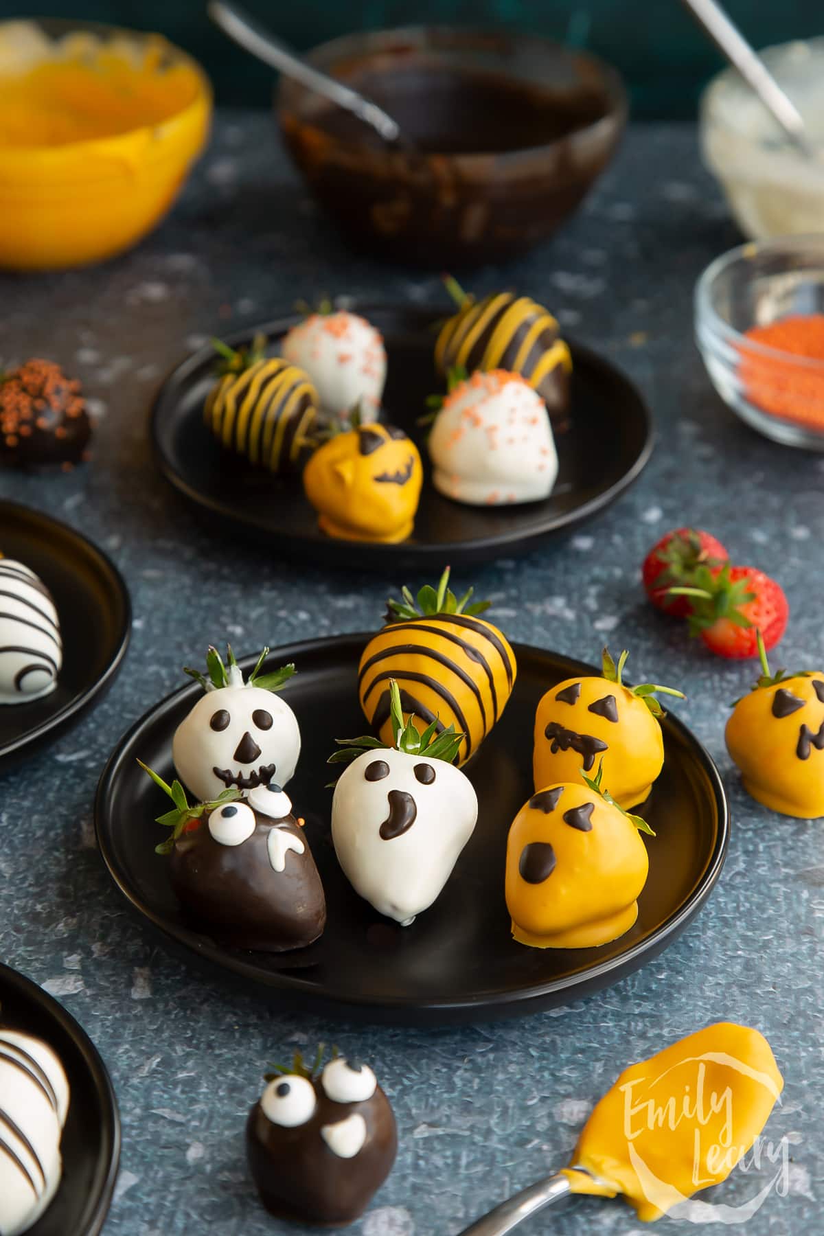 A plate of finished halloween chocolate covered strawberries.