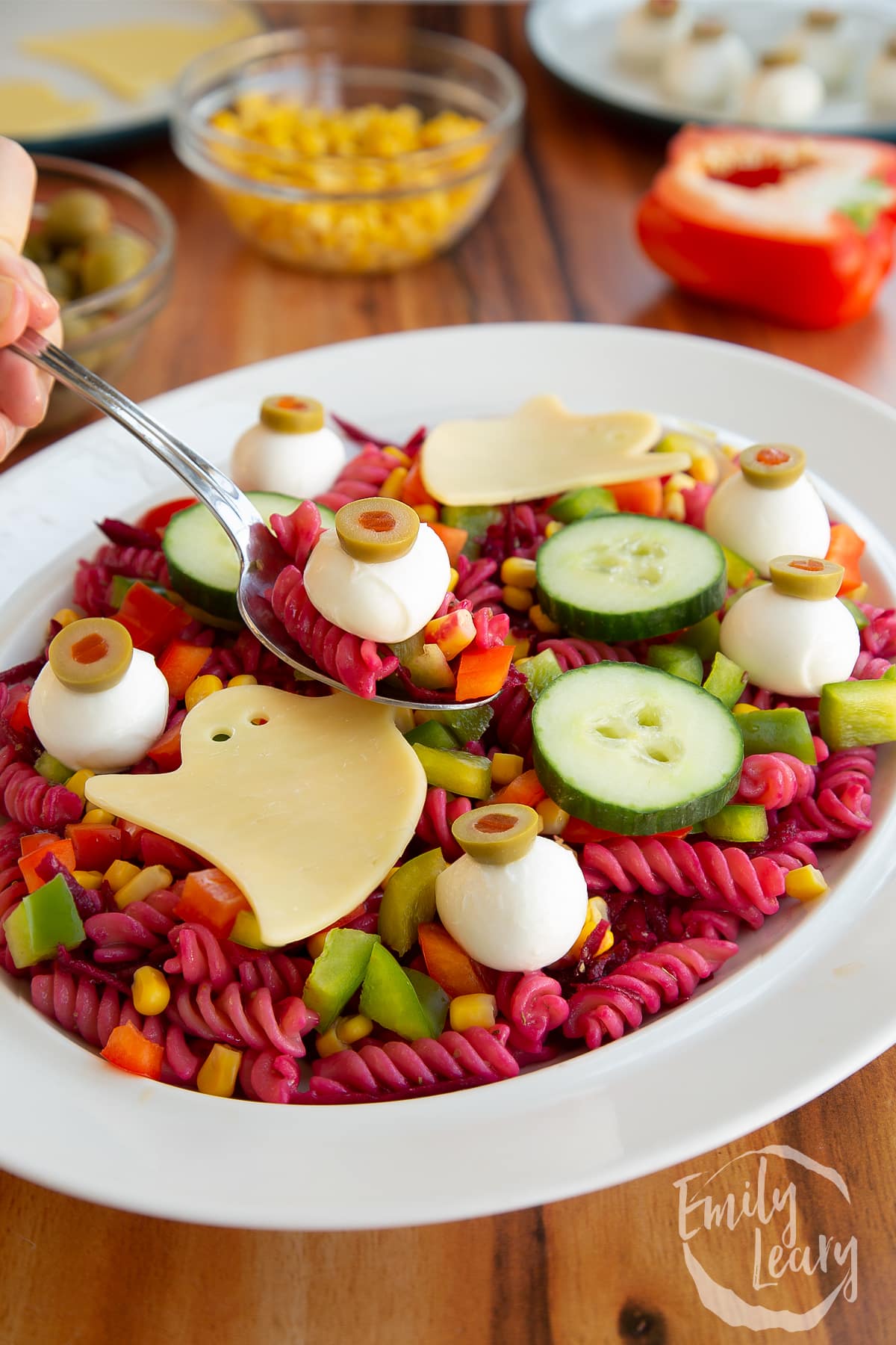 A spoon full of the halloween salad coming out of the bowl.