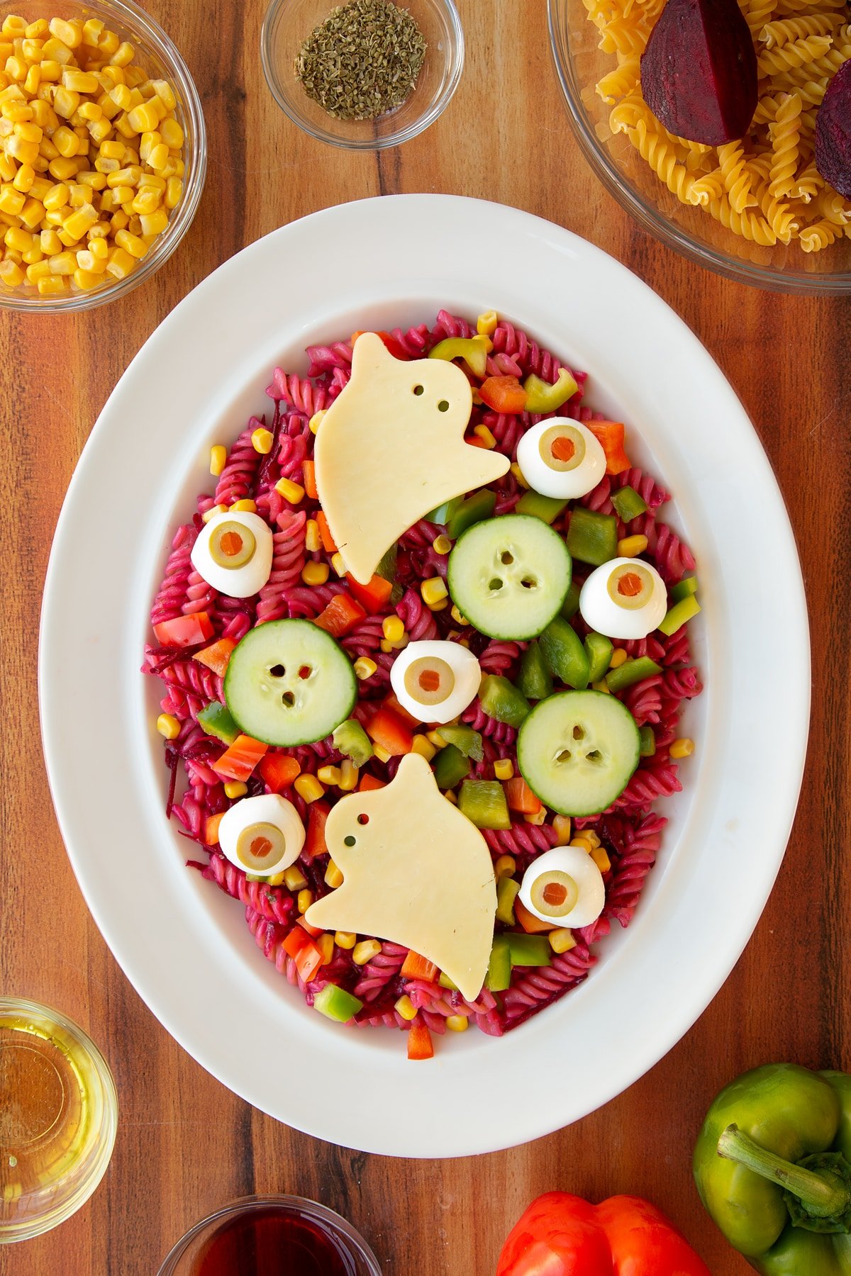 Adding the veggie and cheese monsters to the top of the finished halloween salad.