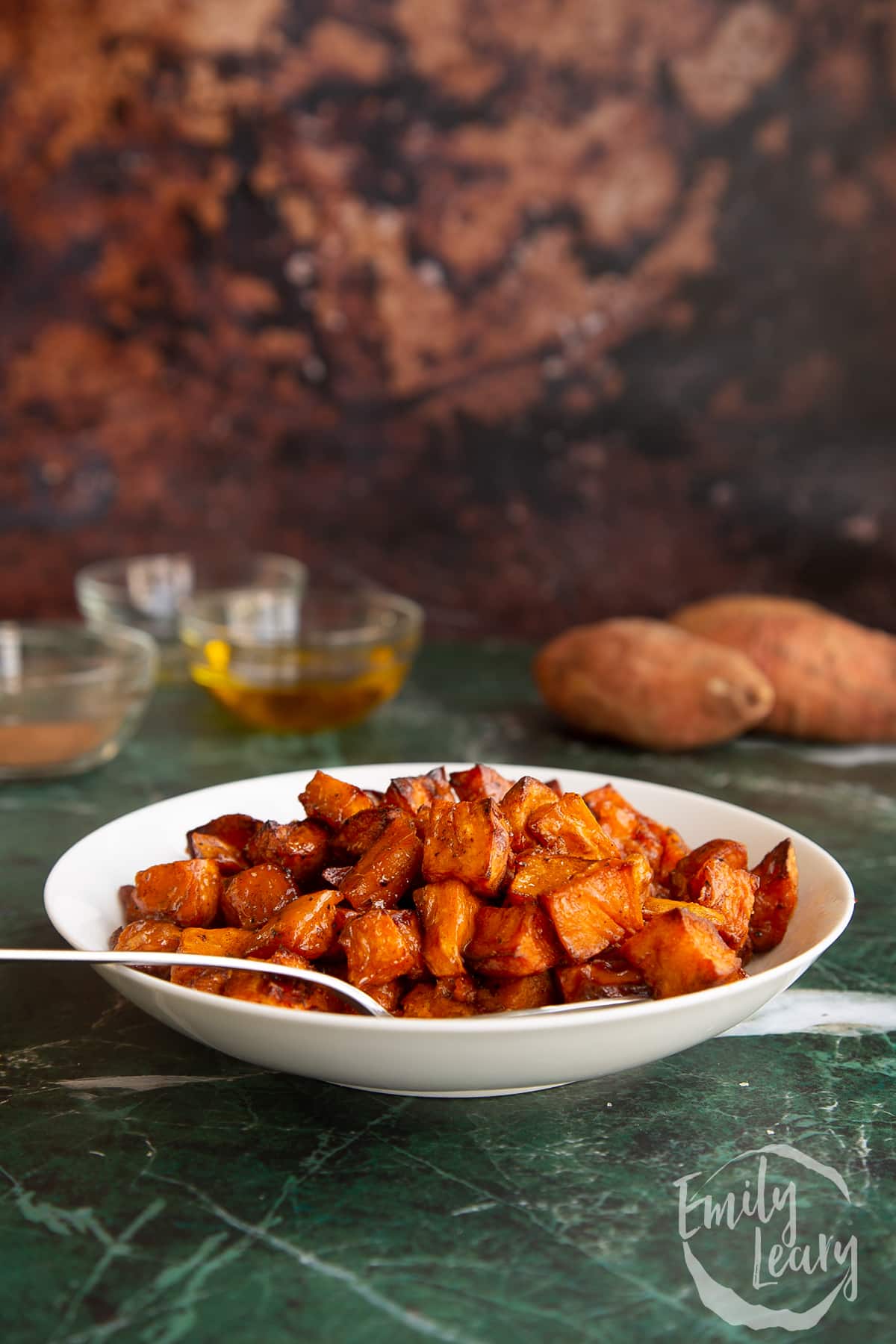 Side on shot of the finished caramelised sweet potatoes in a serving bowl.