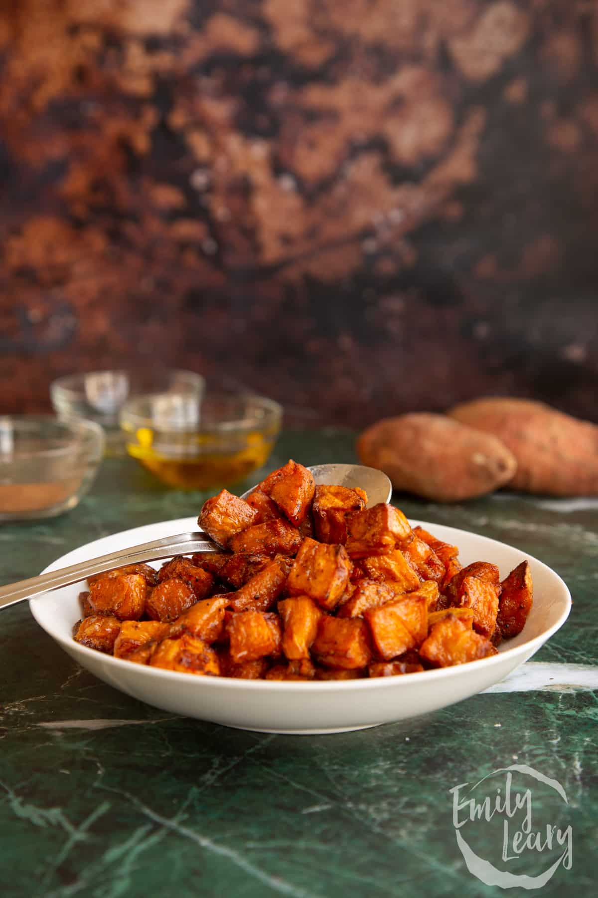 Spoon in a bowl of finished caramelised sweet potatoes.