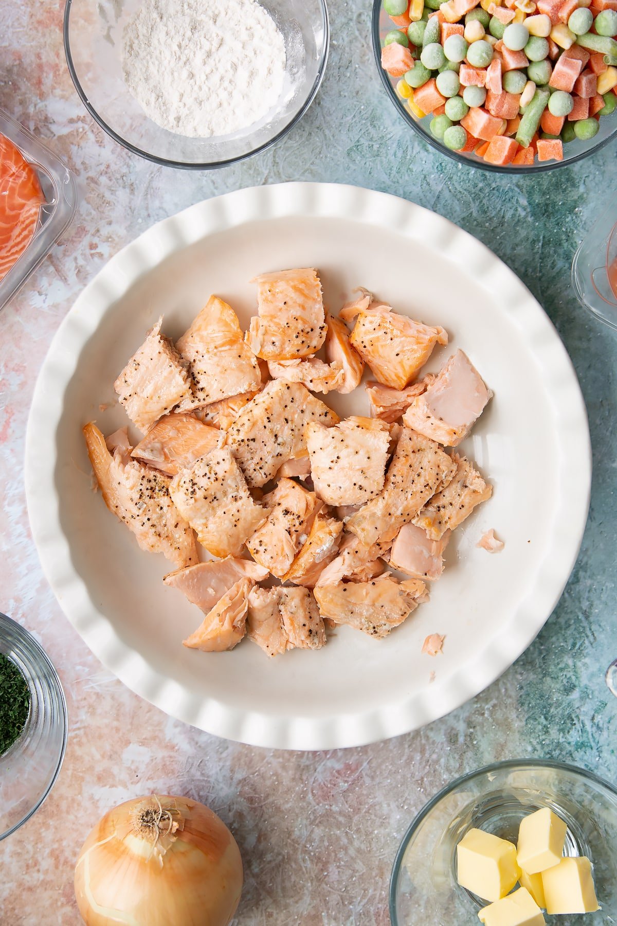 Overhead shot of the salmon having been cut into pieces and assembled into the pie dish.